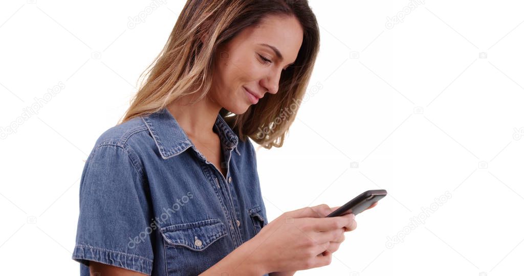 Pretty Caucasian woman texting her boyfriend in studio with copyspace