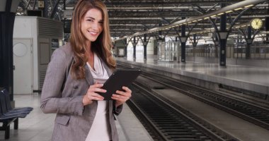 Tren istasyonunda pad aygıtta muhteşem şık beyaz kadın