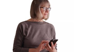 Güzel olgun kadın metinler üzerinde beyaz kopyalama alanı göndermek için akıllı telefon aygıt kullanma