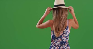 Yeşil ekran üzerinde fedora ve romper içinde genç beyaz kadın arkadan görünüş