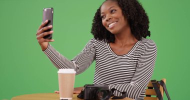 Güzel genç siyah kadın selfie telefon ile yeşil ekranda kafede alarak