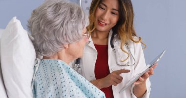 Japon Doktor Olgun kadın hasta ile konuşurken tablet kullanma