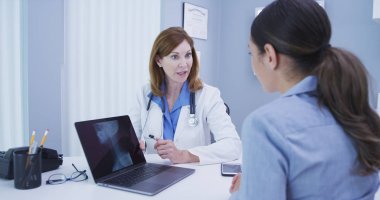 Büyüleyici kıdemli doktor hasta ile omurga xray sonuçlarını tartışıyor, yakın çekim