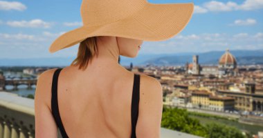 Arkadan Görünüş Floransa'da şık kadın turist trendy sunhat giyiyor