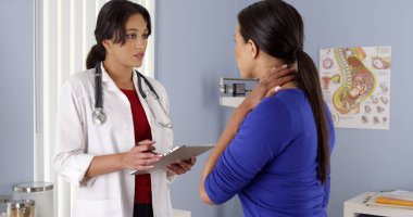 Hispanic OBGYN talking to african american patient with tablet clipart