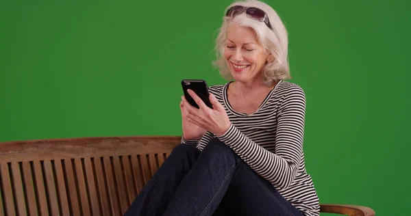 Oude Witte Vrouwelijke Gebruikend Mobiel Apparaat Bankje Groen Scherm Glimlachen — Stockfoto
