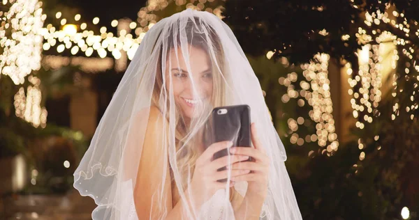 若い花嫁のウェディング ドレスとヴェール携帯電話屋外で Selfie を取って — ストック写真