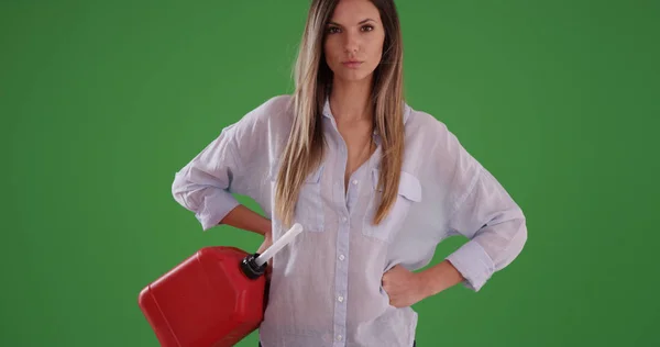 千禧年妇女拿着红色汽油罐头与手在臀部在绿色屏幕上 — 图库照片