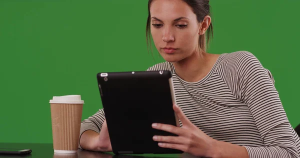 グリーン スクリーンのタブレット コンピューターを使用してカフェのテーブルに座って千年の女性 — ストック写真