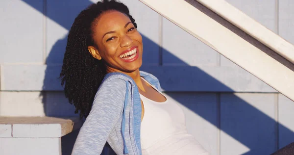 Açık Merdivenler Gülüyor Üzerinde Oturan Mutlu Siyah Kadın — Stok fotoğraf