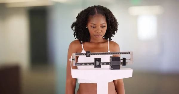 不幸な若い女性彼女自身の重さスケール体重増加に不満 — ストック写真