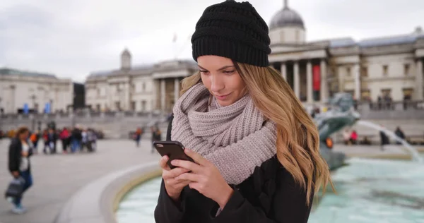 Mulher Chapéu Aconchegante Lenço Mensagens Com Dispositivo Móvel Trafalgar Square — Fotografia de Stock
