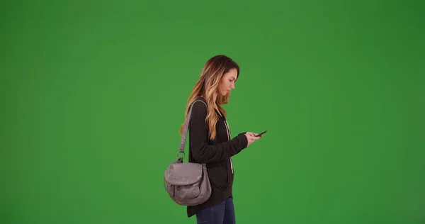 Μελαχρινή Νεαρή Γυναίκα Γρι Γρι Χρησιμοποιώντας Smartphone Στην Πράσινη Οθόνη — Φωτογραφία Αρχείου