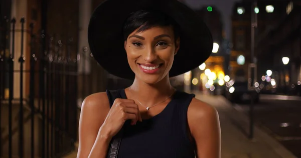 彼女の財布と帽子でポーズ都会の若い魅力的な黒人女性 — ストック写真