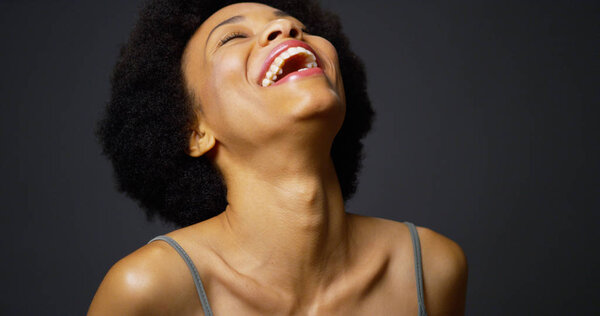 Slow pan up casual black woman laughing and smiling