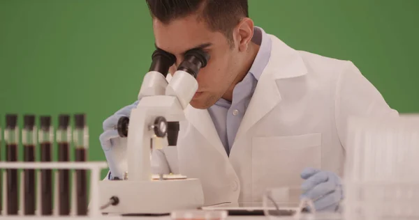 Tysiąclecia Hiszpanie Naukowiec Medyczny Patrząc Przez Mikroskop Zielony Ekran — Zdjęcie stockowe