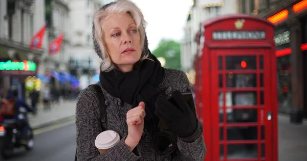 Senior Vrouw Vakantie Londen Wachten Voor Rideshare Met Mobiele Telefoon — Stockfoto
