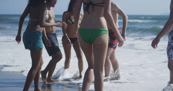 Горячая Молодая Женщина Брызгает Водой Группой Этнических Друзей Пляже — стоковое фото