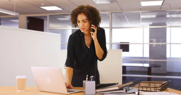 Kobieta Przy Użyciu Komputera Przenośnego Biurze Podczas Słuchania Urządzenia Smartphone — Zdjęcie stockowe