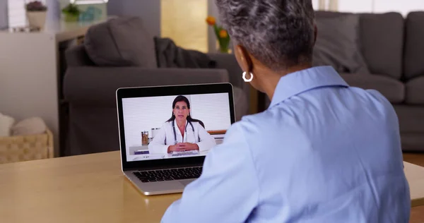 ウェブカメラでシニアのアフリカの女性患者に話して医師 — ストック写真