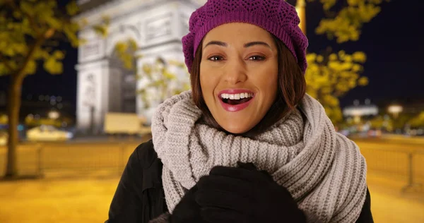 Smiling Latina woman trying to stay warm in cozy hat and scarf