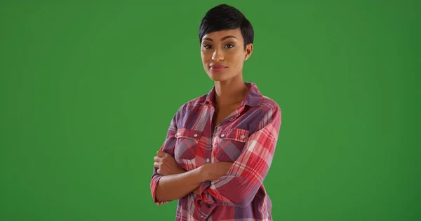 自信的黑人妇女在格子衬衫摆姿势手臂交叉在绿色屏幕上 — 图库照片
