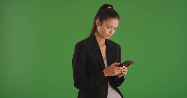 スマート フォンを使用して緑色の画面でテキスト メッセージを送信するプロの女性 — ストック写真