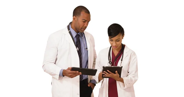 African American doctors talk while using their tablets on a white background