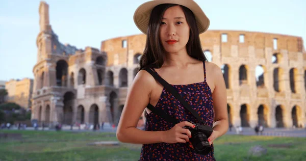 Close up of Asian millennial taking photo in front Colosseum Rome Italy