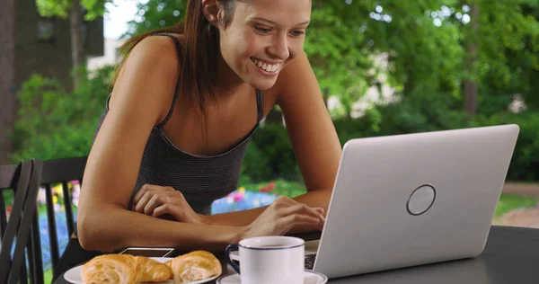 屋外でノート パソコンで閲覧しながら朝食を食べてかなり白人女性 — ストック写真