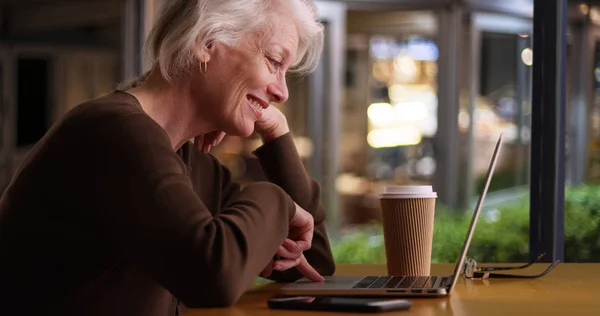 Lykkelig Eldre Kvinne Som Leser Internett Kaffebar Med Wifi – stockfoto