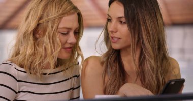 Evin içinde oldukça esmer kadın gösteren sarışın arkadaş akıllı telefon yakın çekim