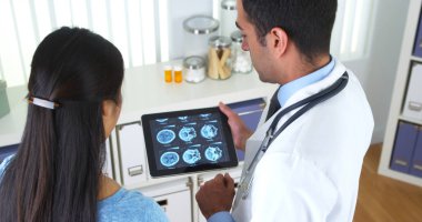 Mexican doctor explaining brain scans to patient clipart