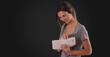 O koyu gri arka plan üzerinde alınan posta yoluyla arayan genç beyaz kadın