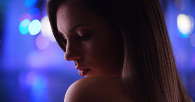 Güzel kadın canlı bulanık arka plan üzerinde dramatik yan görünümü close-up