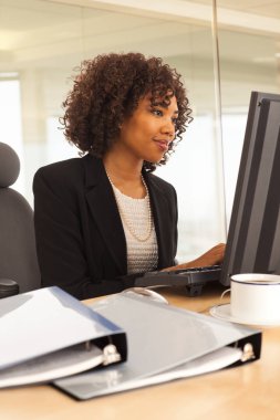 Genç işkadını kapalı masa başında bilgisayarla Ofis Binası