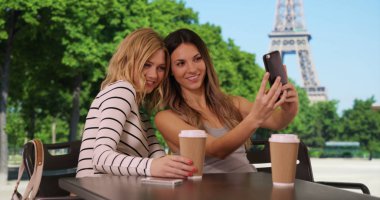 Sevimli beyaz kızlar alarak selfie akıllı telefon tarafından Eyfel Kulesi ile oturmuş