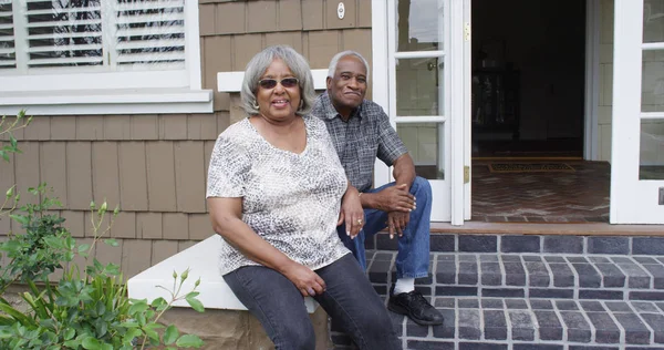 Happy retired black couple sitting outdoors