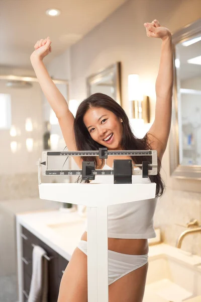 Beautiful Asian millennial woman excited she lost weight