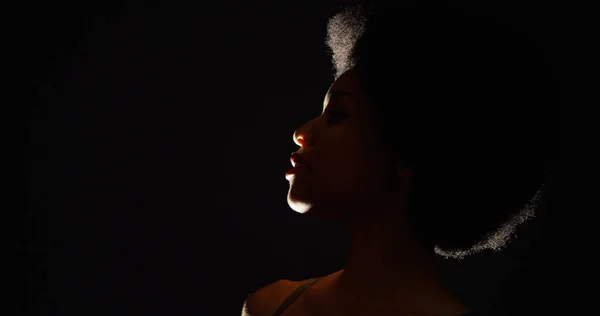 黒人女性は ボトルから水を飲むのバックライト付きスタジオ撮影 — ストック写真