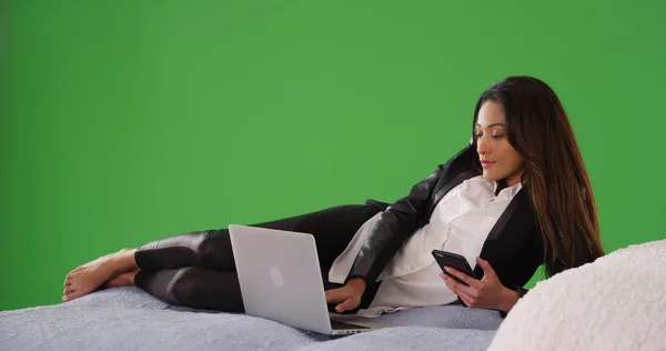 Latina Kobieta Leżąc Łóżku Laptopa Telefon Zielony Ekran — Zdjęcie stockowe