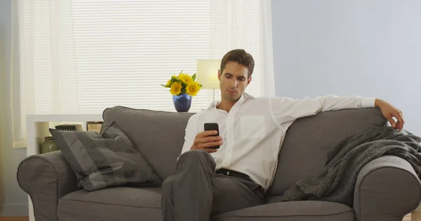 Άνθρωπος Χρησιμοποιώντας Smartphone Στο Σπίτι Στον Καναπέ Μετά Δουλειά — Φωτογραφία Αρχείου