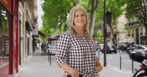 Strong independent woman stands boldly on a Paris sidewalk