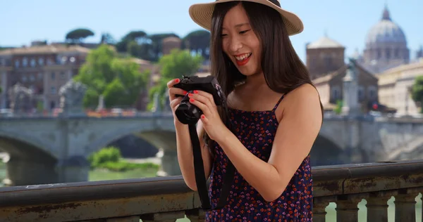 Closeup of Asian millennial photographer taking pictures by the Vatican in Rome