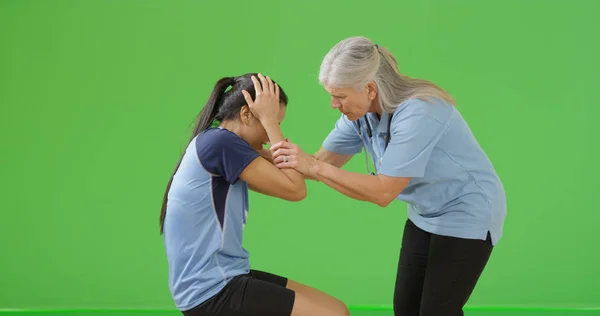 Vecchio Paramedico Donna Esaminando Infortunio Del Giocatore Calcio Sullo Schermo — Foto Stock