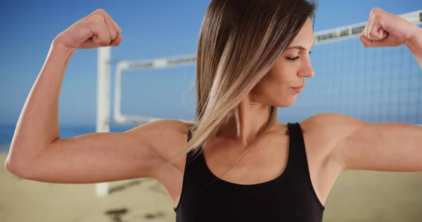 适合白种人女孩在她的20多岁展示手臂肌肉沙滩排球网 — 图库照片