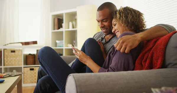 ソファの上のデバイスを使用してアフリカ系アメリカ人のカップル — ストック写真
