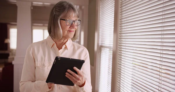 Suave Señora Madura Utilizando Dispositivo Almohadilla Inalámbrica Por Ventana Sala — Foto de Stock