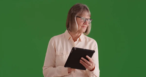 Charming White Female Senior Using Pad Device Green Screen — Stock Photo, Image