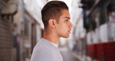 Yan görünüm serin İspanyol adamla ayakta şehir sokakta kesme vuruşu.